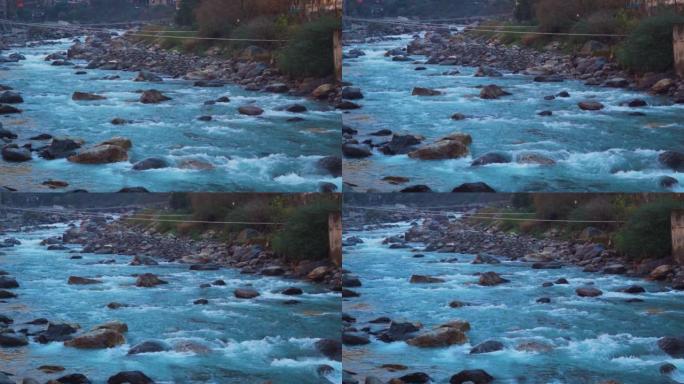 印度喜马al尔邦Kasol的Paravti河在山脉之间流动的慢动作镜头。冬季的帕尔瓦蒂河景色。山脉背