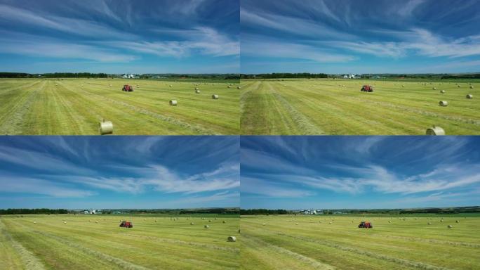 拖拉机的鸟瞰图使用拖车打包机在野外收集秸秆并制成圆形大包。干草。拖拉机收集干草和做干草堆。
