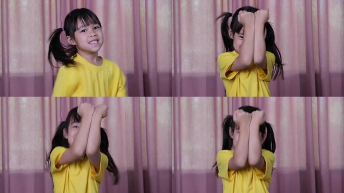可爱的小女孩在室内做拳击动作和空中运动。有趣的小拳击女孩在家里的粉红色窗帘背景。