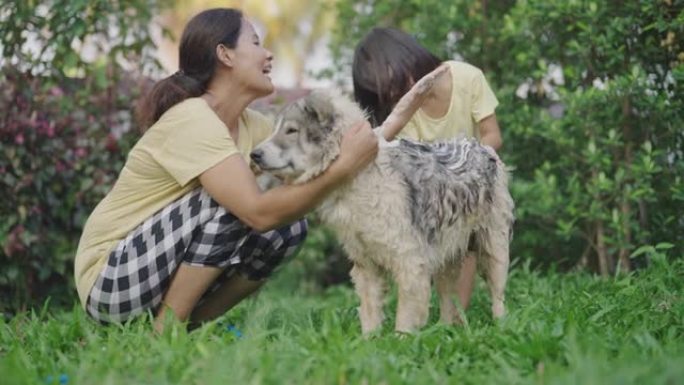 亚洲妈妈和小女儿洗狗。
