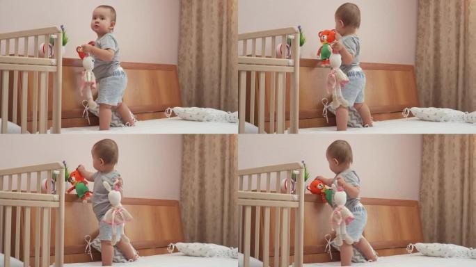 12-17个月大的新生女孩玩针织玩具老虎和野兔站在父母的床上