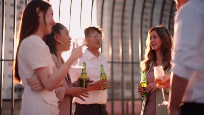 多元而快乐的亚洲商人在阳光普照的屋顶上的包容性工作场所办公空间庆祝员工聚会的成就