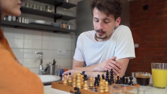 两人青年男女夫妻在厨房的桌子上玩棋盘游戏早晨例行休闲活动夫妻恋爱学习玩真人复制空间