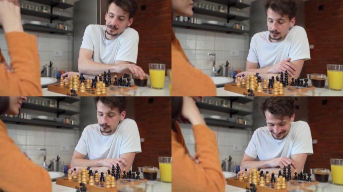 两人青年男女夫妻在厨房的桌子上玩棋盘游戏早晨例行休闲活动夫妻恋爱学习玩真人复制空间