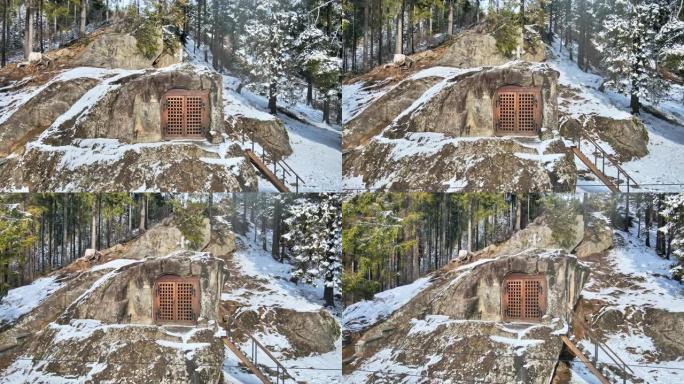 罗马尼亚冬季隐士丹尼尔牢房的空中无人机视图。雪，周围的森林