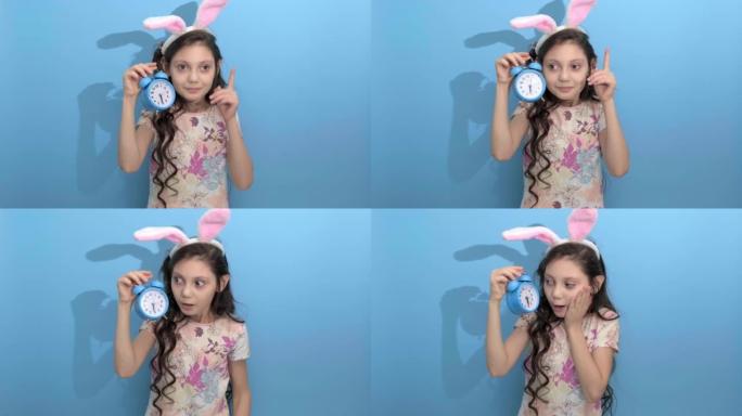 复活节快乐。复活节兔子耳朵里美丽可爱的女孩拿着闹钟