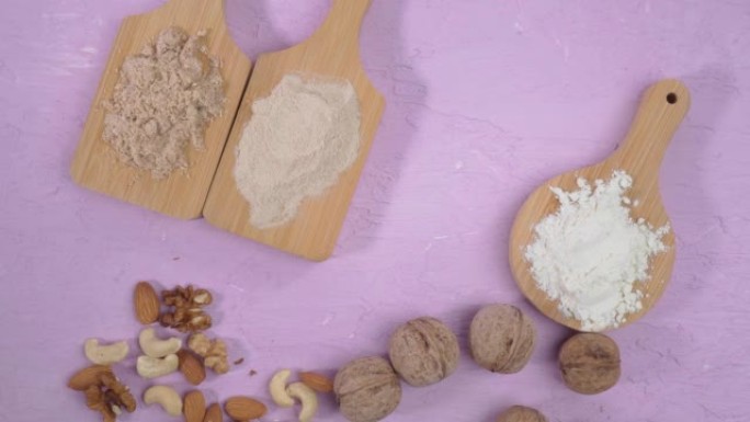 替代坚果面粉。素食烘焙。杏仁、核桃、腰果面粉。平铺紫色背景