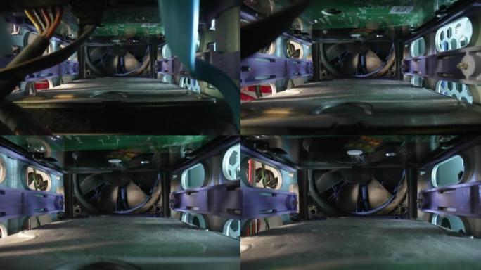 摄像机在一个旧的尘土飞扬的计算机系统单元内移动。相机放大冷却器，风扇被灰尘覆盖。特写电脑元件、数字技