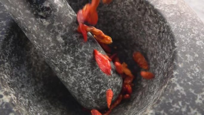 红辣椒豆荚在石臼中掉落和弹跳的特写