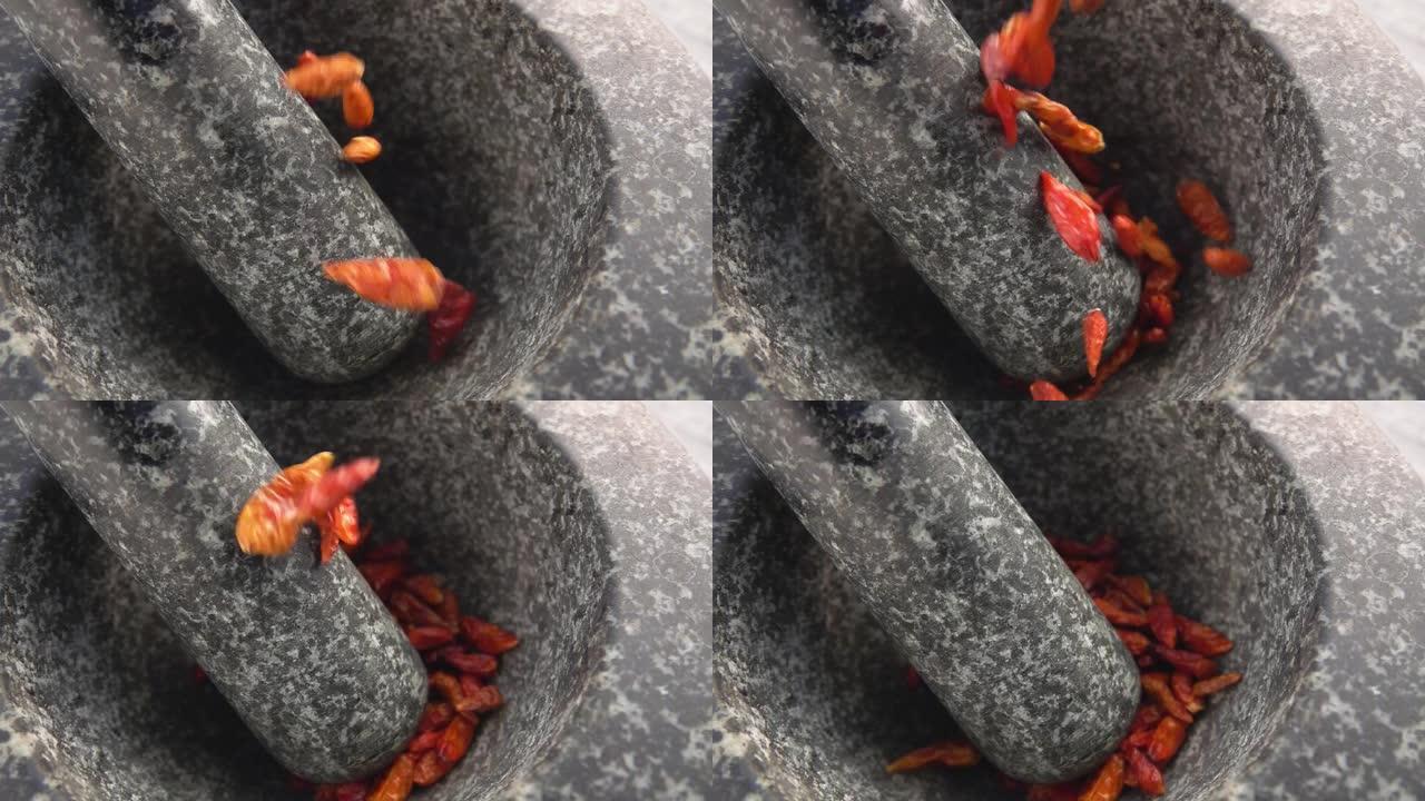 红辣椒豆荚在石臼中掉落和弹跳的特写