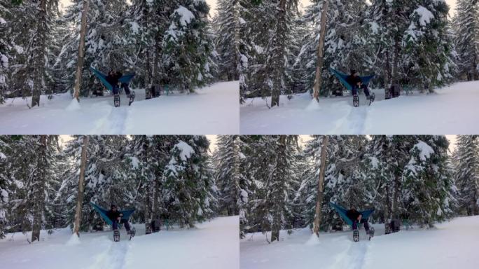 徒步旅行者带着雪鞋喝咖啡，躺在冬季森林的吊床上