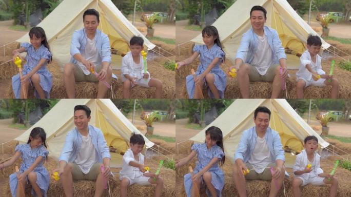 快乐亚洲家庭在帐篷外吹肥皂泡