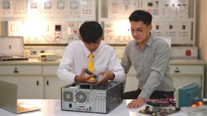 亚洲学生向电子技师老师学习拆卸和固定主板进行清洁。电脑维修。从板上移除处理器