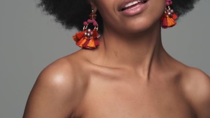 一个戴着耳环的黑人微笑女人的锁骨特写