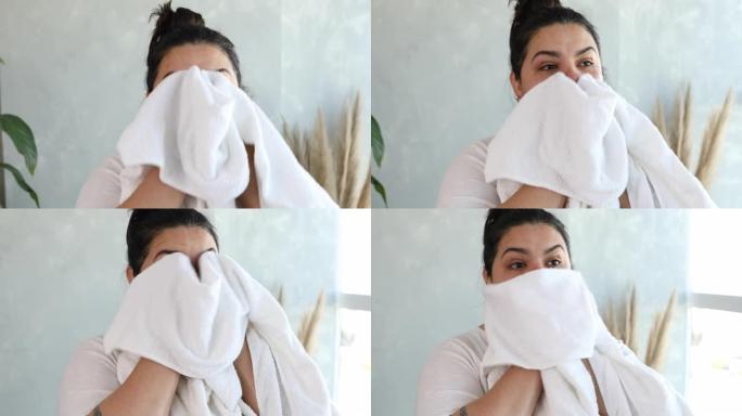 成年妇女用毛巾擦干脸