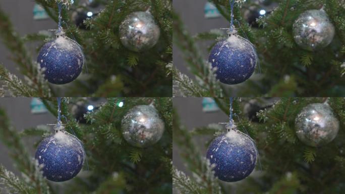 蓝色和银色的球挂在家里的圣诞树树枝上