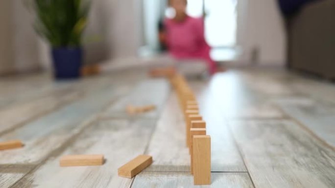 小女孩在家玩木块多米诺摔倒，通过玩活动学习