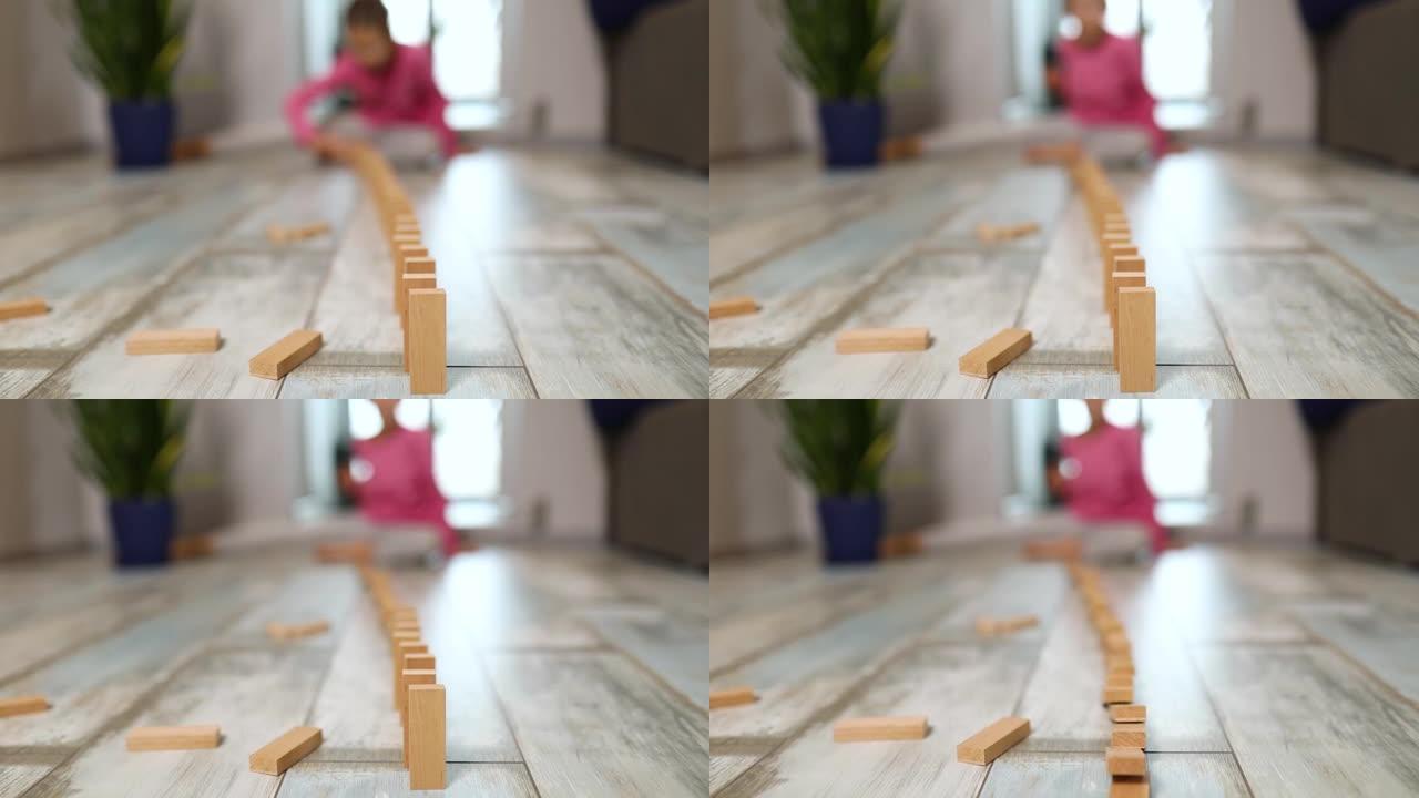 小女孩在家玩木块多米诺摔倒，通过玩活动学习