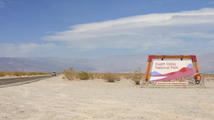 汽车驶过加利福尼亚州死亡谷国家公园的入口标志
