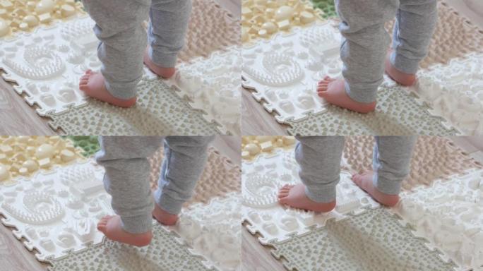幼儿在婴儿足部按摩垫上练习，腿部矫形按摩地毯。预防平足矫形按摩拼图地垫儿童发育。