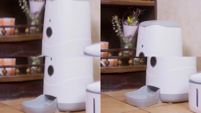 相机拍摄了自动宠物喂食机的自下而上的视图，该自动宠物喂食机站在家里的角落，特写镜头。根据时间表和计时