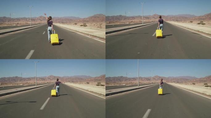 手持镜头: 年轻的女性旅行者带着黄色行李4k走在hihgway上