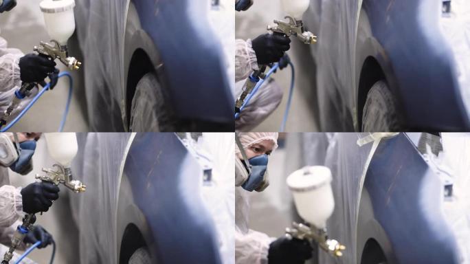 汽车油漆工在专用展位的汽车机翼上喷漆。在汽车维修车间喷漆漆车零件。汽车修理制造厂