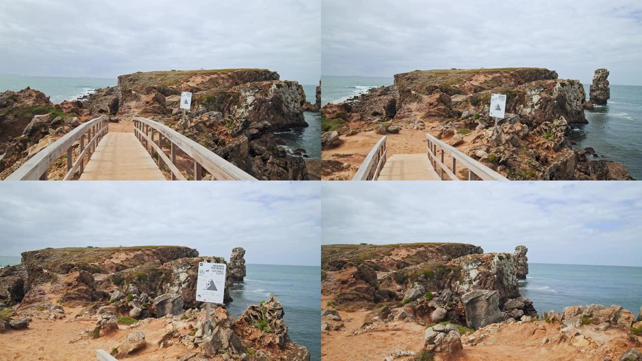 一座木桥以4k的方式连接着海边岩石悬崖的两侧。