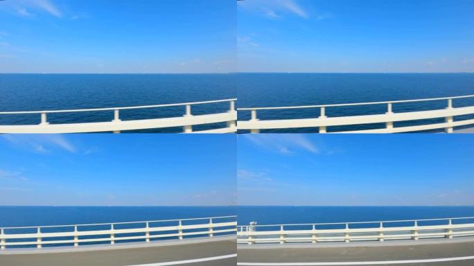在东京Aqualine高速公路上行驶。车窗上的大海