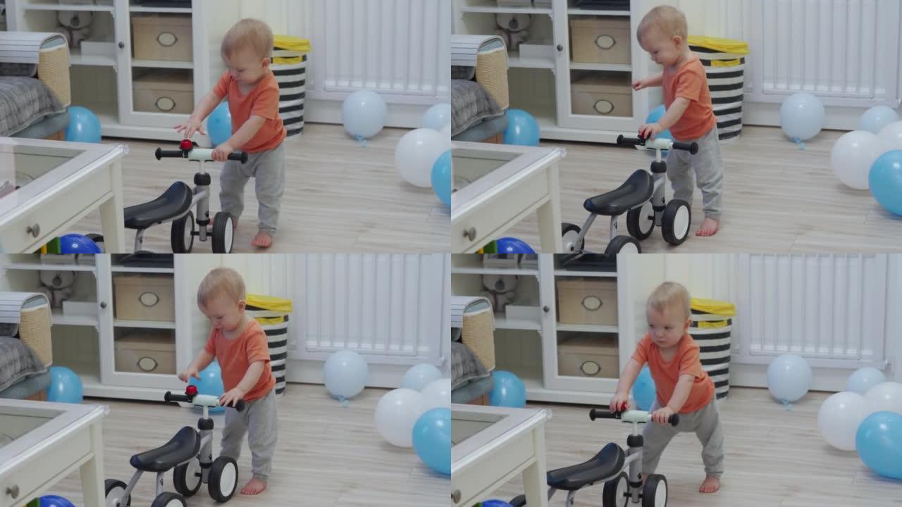 庆祝他的第一个生日的孩子收到了一个平衡自行车作为礼物，男婴在婴儿平衡自行车为1岁的孩子骑玩具。