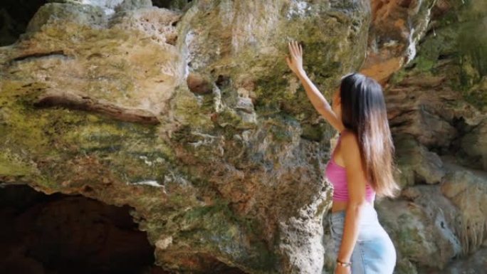 4k年轻的亚洲妇女在暑假在热带岛屿海滩的洞穴中行走