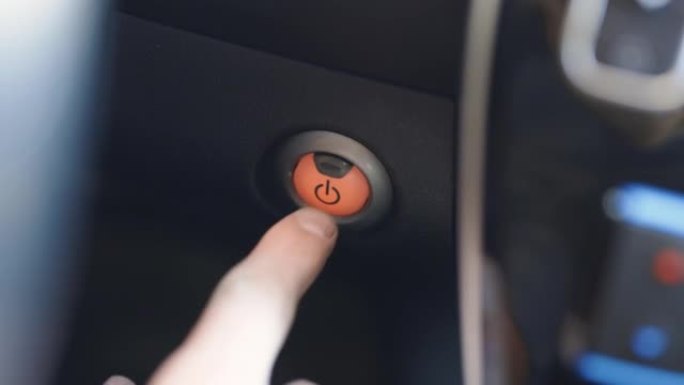 按下电源点火按钮启动停止无钥匙点火混合电动汽车发动机。启动停止电动汽车发动机。手指按下按钮启动停止电
