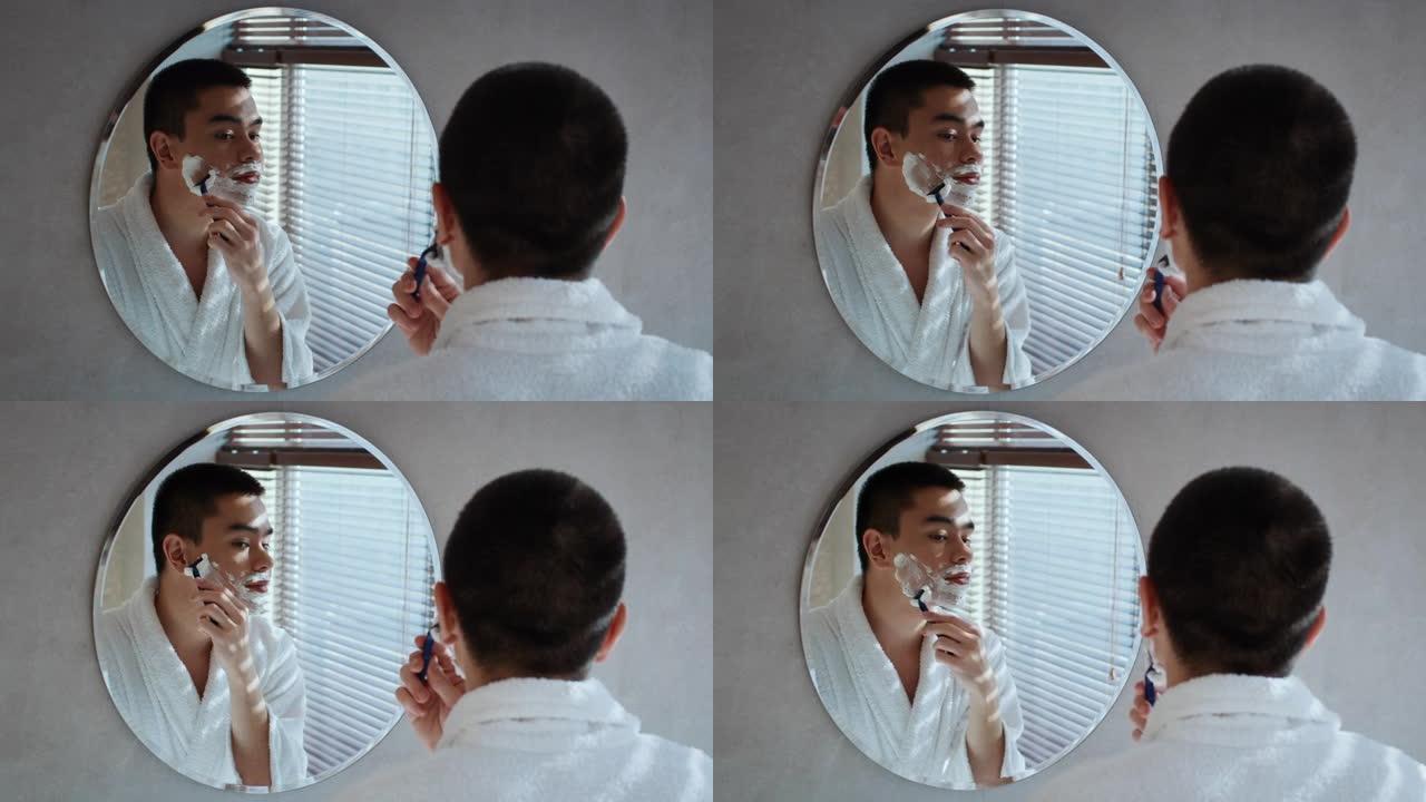 日本男子剃光面站在浴室镜子附近