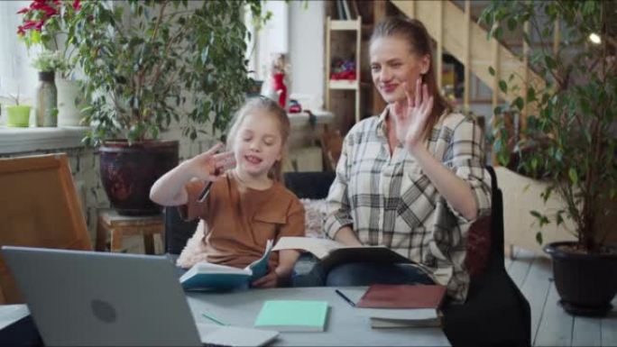 妈妈和女孩通过互联网与家教订婚。他们打开笔记本电脑，向老师打招呼