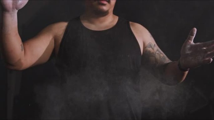4k视频片段，一名男子在健身房撒上灰尘