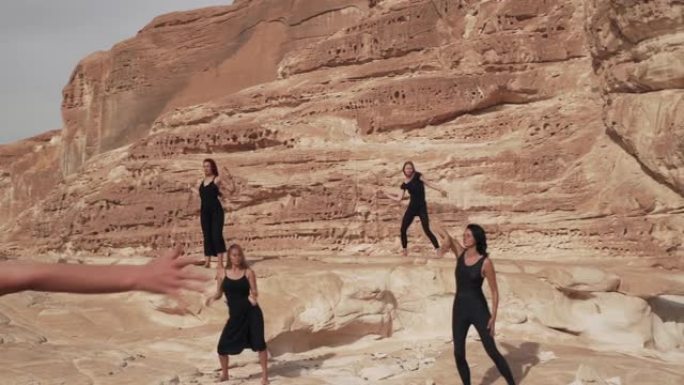 一群穿着黑衣的妇女在沙漠峡谷中练习狂喜的舞蹈