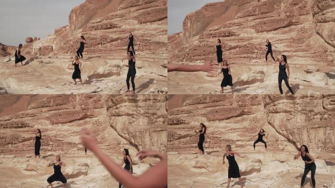 一群穿着黑衣的妇女在沙漠峡谷中练习狂喜的舞蹈