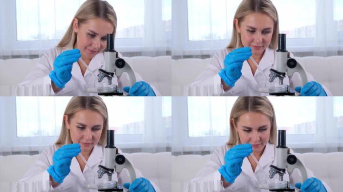 女实验室助理在实验室的桌子上工作时使用显微镜分析样品，进行研究