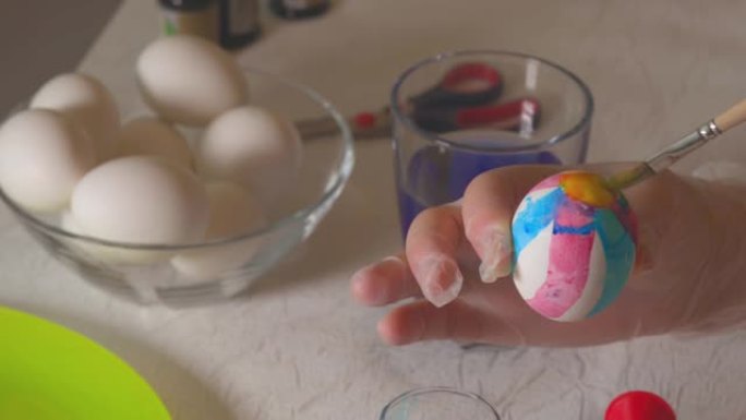 一个男孩学习用特殊器具画复活节彩蛋的美丽景色。假日概念。瑞典。