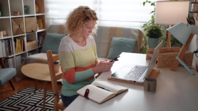 白人妇女在家庭办公室工作时使用手机的侧视图