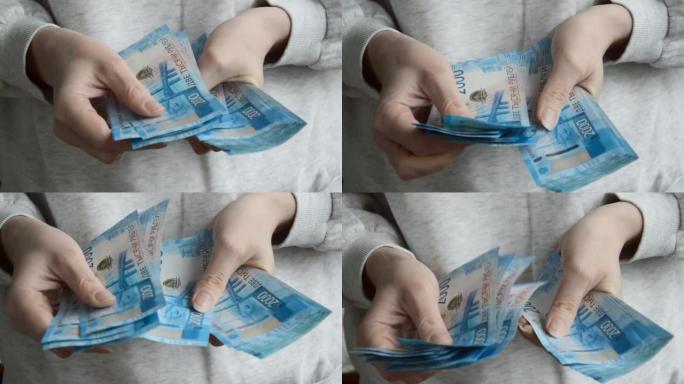 一个女人用手数钞。俄罗斯的钱，卢布。