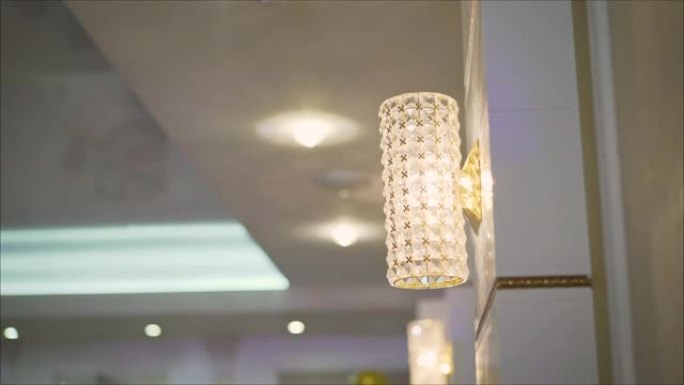透明水晶圆形吊灯，墙壁上有爱迪生灯泡的烤灯，带有小三角形图形黑白瓷砖。概念室内阁楼，现代设计餐厅，公