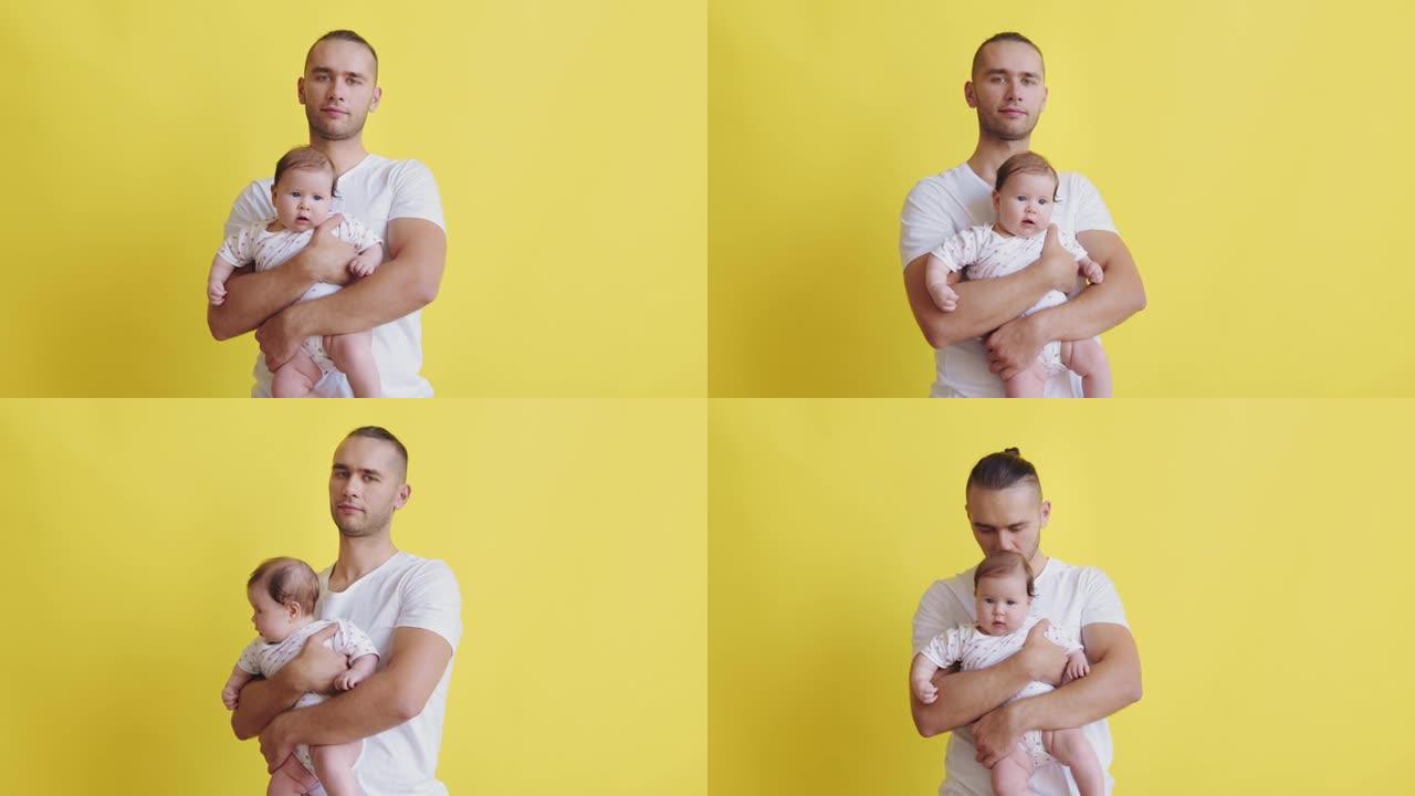 一位年轻英俊的父亲的肖像，怀里抱着他的小女儿，正看着孤立在黄色背景上的相机。千禧一代年轻家庭