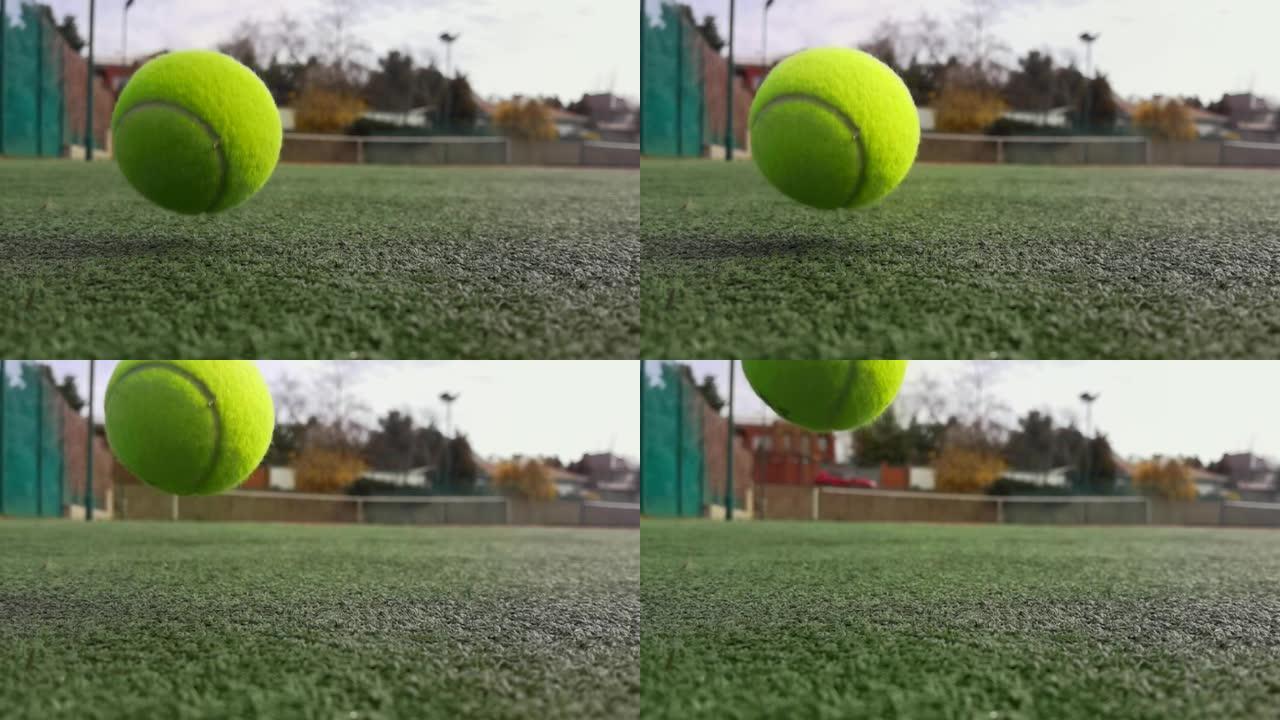 黄色网球在超级慢动作1000 fps在白线旁边的粘土绿色球场上，复制空间，软焦点和背景网。运动、娱乐