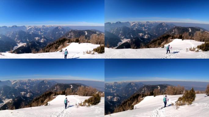 活跃的女人，背着背包，在弗赖贝格的山峰上，可以欣赏到奥地利卡林西亚卡拉万克斯的白雪皑皑的山峰。泽尔·