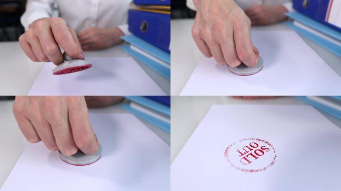 在桌子上的文件上贴上红色售罄邮票的人