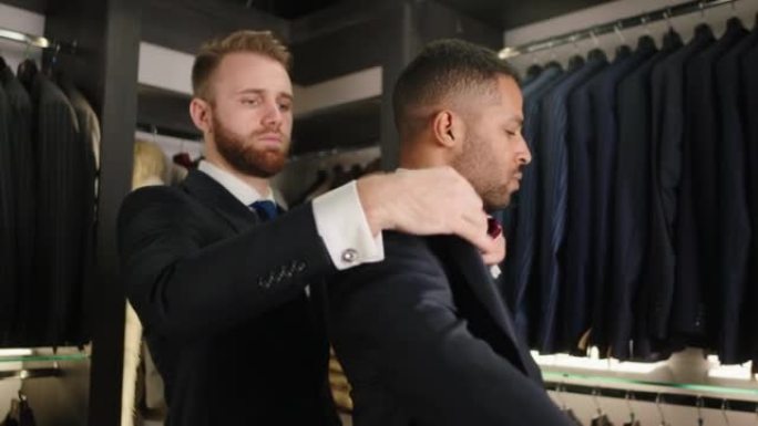 豪华西装店的顾问男人在他的客户上尝试穿着美国黑人男人好看从设计时装和手工制作的新系列概念