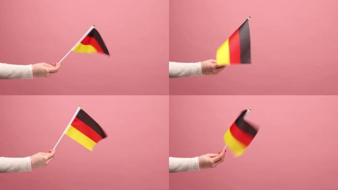 侧面特写的妇女手握德国国旗，庆祝德国日- 10月3日。