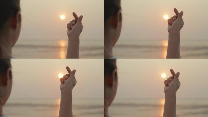 热带日落时海边迷你心形剪影手指