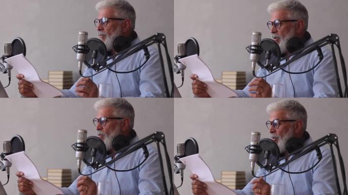 男人在录音棚录制播客或用麦克风采访。资深音响工程师或电台主持人。一个成年的白发男子创建音频内容
